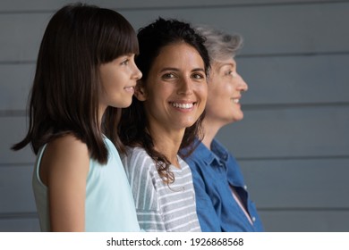 Portrait Of Smiling Young 30s Latino Woman With Little Daughter And Elderly Grandmother Pose On Grey Background. Three Generations Of Women In Row, Adult Grownup Female With Child And Grandparent.