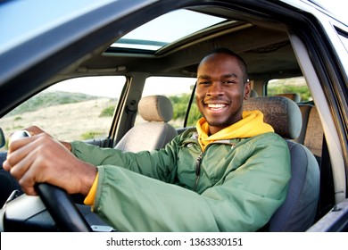 Portrait of smiling young african american man driving car - Shutterstock ID 1363330151