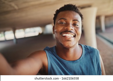 Portrait of a smiling young african american man taking selfie after jogging at outdoors