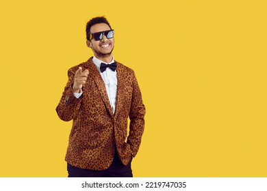 Portrait of smiling young African American man in animal print jacket isolated on yellow studio background. Happy black fashionable male point at camera screen. Copy space. Style and fashion. - Powered by Shutterstock