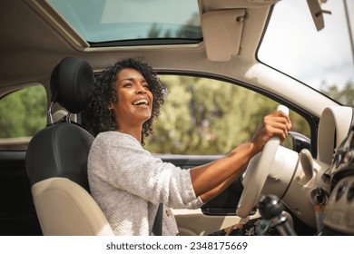 Portrait smiling young african american woman driving car