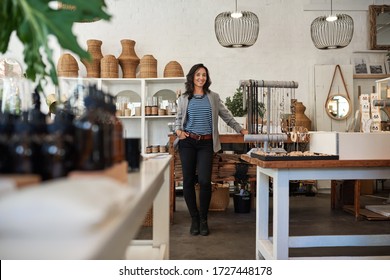 Portrait Of A Smiling Young Asian Business Owner Standing By A Counter In Her Trendy Shop