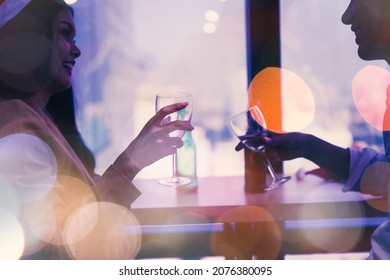 Portrait Of Smiling Young Asian Man And Woman Clanging Wine Glasses. Pretty Single Girl Flirting With Young Handsome Man In A Bar. Enjoy Party Concept.