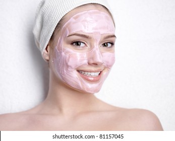 Portrait Of Smiling Young Beautiful Woman With Pink Facial Beauty Mask