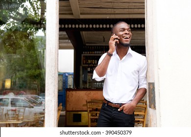 Portrait of a smiling young black businessman talking on mobile phone 