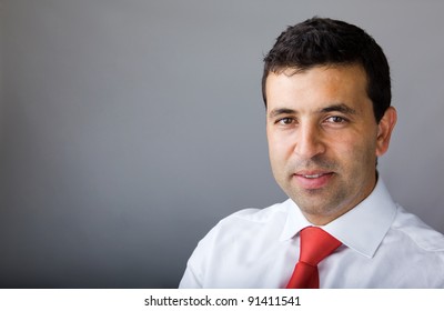 Portrait Of Smiling Young Business Man On Grey Background