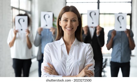 Portrait of smiling young Caucasian employee successful at interview in office, hired for vacant position. Diverse people with question mark on background. Recruitment, employment concept.