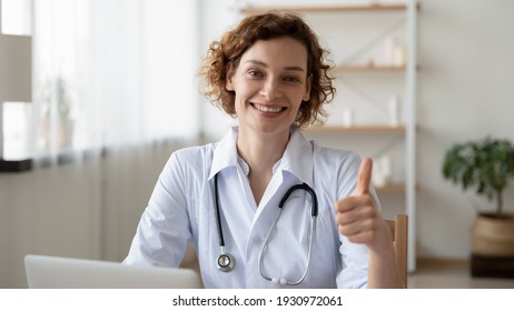 Portrait of smiling young Caucasian female doctor in white medical uniform show thumb up give recommendation to good quality medical service. Woman nurse or GP recommend hospital or clinic.