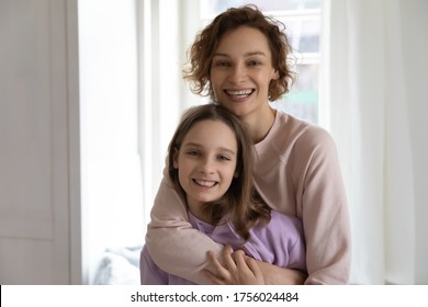 Portrait of smiling young Caucasian mother and teenage daughter hug and cuddle, happy mom and teen girl child stand embracing, show love and understanding in relationships, family bonding concept
