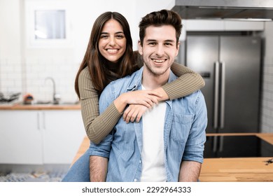 portrait of smiling young couple in the kitchen at home. Handsome man and beautiful woman standing together ans looking at camera. Lifestyle concept. - Powered by Shutterstock