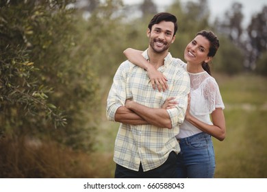 Portrait of smiling young couple standing together at olive farm - Powered by Shutterstock