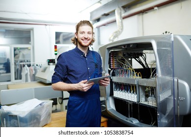 Portrait Of Smiling Young Engineer Standing Near The Printing Machine