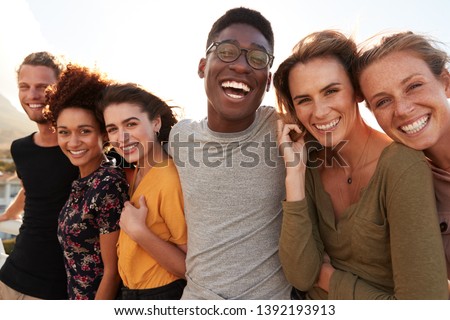 Portrait Of Smiling Young Friends Walking Outdoors Together