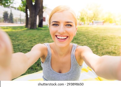 POrtrait Of A Smiling Young Girl Making Selfie Photo In Park