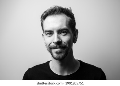 Portrait Of Smiling Young Man On Gray Background. Black And White