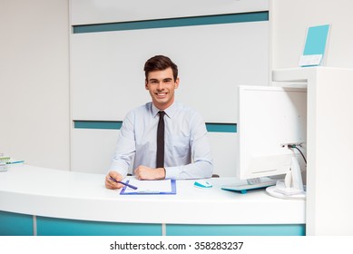 Portrait of smiling young man with receptionist in dentist office - Powered by Shutterstock