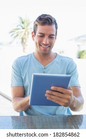 Portrait of a smiling young man using digital tablet at home