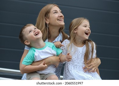 Portrait Of Smiling Young Mother Hugging Her Children Son And Daughter. A Happy Family. Close-up