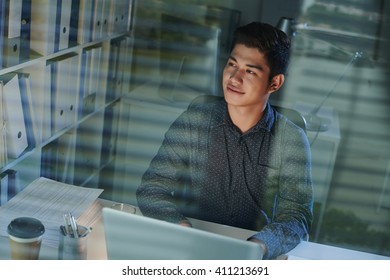 Portrait of smiling young office worker at his desk