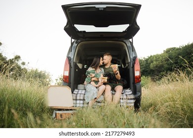 Portrait Of Smiling Young Parents Embarrassing Their Little Daughter And Dog With Delicious Pizza. Happy Family Of Three Having Weekend Party On Fresh Air.