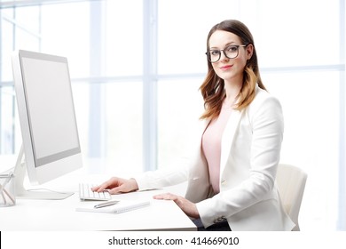 Portrait Of Smiling Young Professional Woman Typing On Keyboard While Working On Computer. 