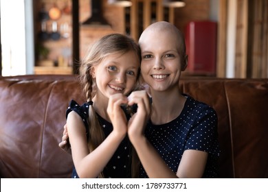 Portrait Of Smiling Young Sick Of Cancer Bald Mom And Little Daughter Hug Show Heart Love Sign Gesture With Hands, Happy Hopeful Ill Hairless Mother Patient With Small Girl Child, Healthcare Concept