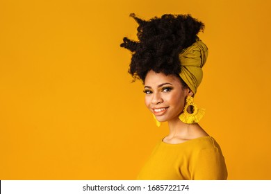 Portrait Of A Smiling Young Woman With Big Yellow Tassel Beaded Earrings And Afro Hair Wrapped With Head Wrap Scarf