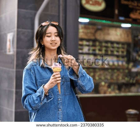 Portrait of a smiling young woman girl eating an ice cream walking in the city, tourists visiting destination, summer trip exploring