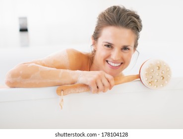 Portrait Of Smiling Young Woman Holding Body Brush