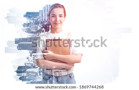 Portrait of smiling young woman holding books in blurry city. Concept of education. Toned image double exposure