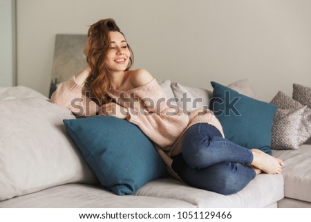 Portrait of a smiling young woman resting while sitting on a couch at home Portrait Smiling Young Woman Resting While Stock Photo (Edit Now ...