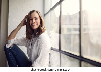 Portrait Of Smiling Young Woman Sitting In A New Yorker Wondow 