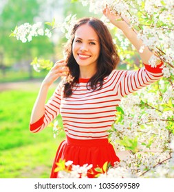 Portrait Smiling Young Woman With Spring Flowers At Garden