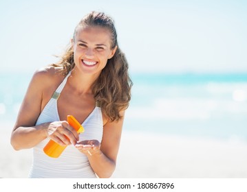 Portrait of smiling young woman with sun block creme