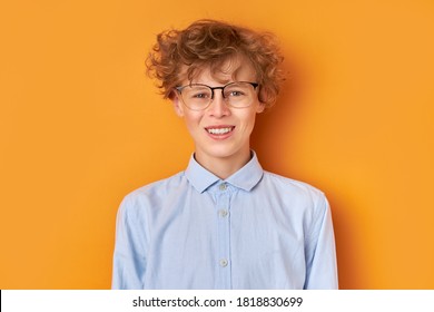 Portrait Of Smiling Young Wonk Boy 14 Years Old Isolated Over Orange Background, Look At Camera. Youth Concept