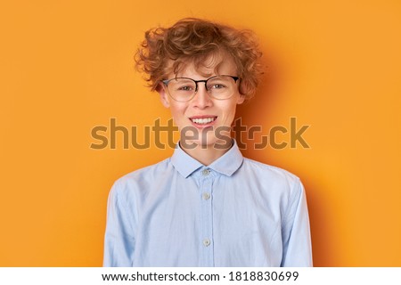 portrait of smiling young wonk boy 14 years old isolated over orange background, look at camera. youth concept