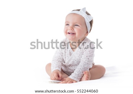 Portrait of a smilling baby girl with hair brush isolated on a white background