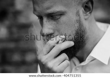 portrait of smoking young red hair man with beard black and white horizontal