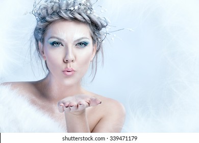 Portrait of snow queen blowing in her palm