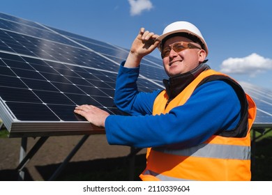 Portrait Of A Solar Farm Worker Leaning Against The Panels