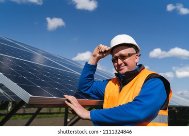Portrait Of A Solar Farm Worker Leaning Against The Panels