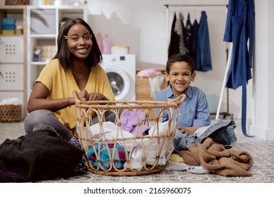 Portrait Son Helps Mother With Household Chores, The Women Sort Laundry, Fold Clothes, Prepare Them For Drying, They Spend Time Together In The Bathroom Talking Smiling.