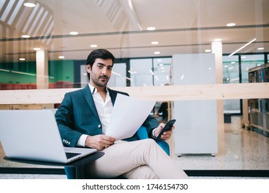 Portrait Of South Asian Businessman Sitting At Desktop With Modern Laptop Computer In Office Interior And Looking At Camera During Time For Work With Financial Documents, Technology Marketing