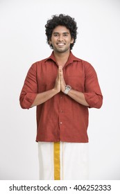 Portrait of South Indian man greeting on white background.