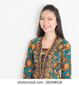 Portrait Of Southeast Asian Woman In Batik Dress On Plain Background.