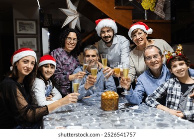 Portrait of spanish multi generational family toasting with champagne during christmas dinner party celebration - Powered by Shutterstock