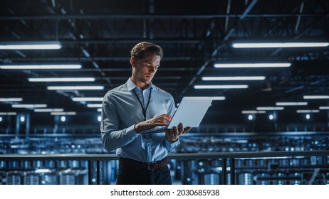 Portrait of IT Specialist Uses Laptop in Data Center. Server Farm Cloud Computing Facility with Male Maintenance Administrator Working. Cyber Security and Network Protection. - Shutterstock ID 2030685938