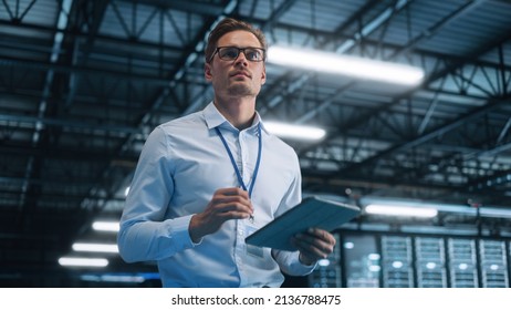 Portrait of IT Specialist Using Tablet Computer in Data Center. Male System Administrator Working with Big Server Farm Cloud Computing Facility. Cyber Security, Network Protection