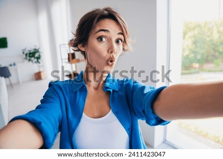 Portrait of speechless impressed girl pouted lips staring cant believe make selfie bright apartment inside