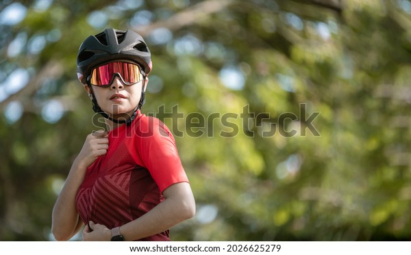 Portrait sport woman wearing sport suite\
helmet,glove and glasses,she competition on  bicycle bike is\
adventure and extream game\
concept.